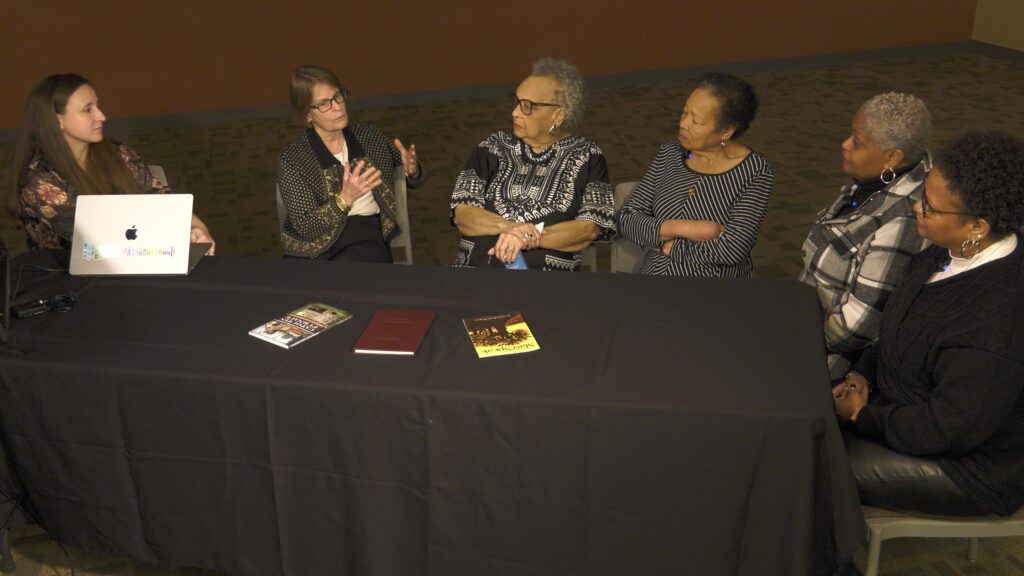 Photo of Agnes and her daughters talking to Éadaoin Harney, and Elizabeth Comer.
