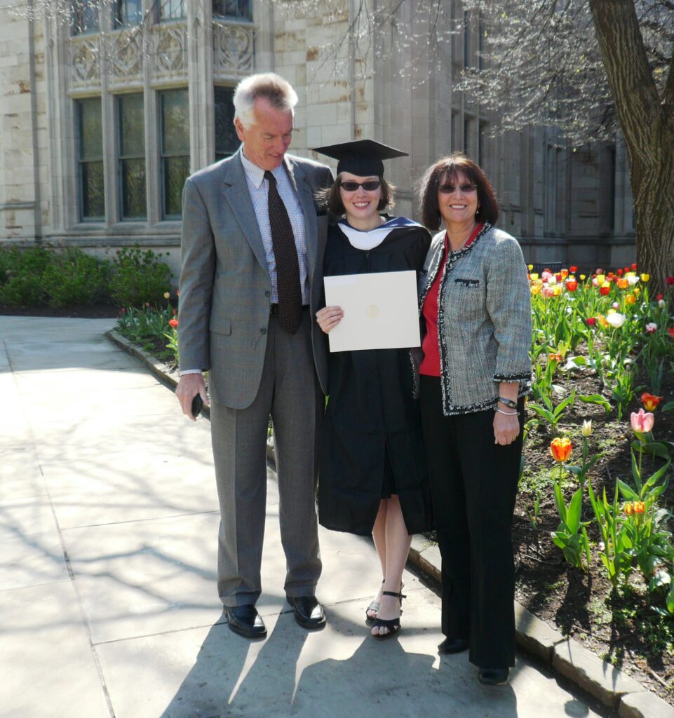 An image of Alexandra with her parents at her college graduation.